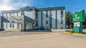 A modern building with a sign reading "HomeTowne Studios" and "Welcome Ship Builders No Cash New Room". - HomeTowne Studios By Red Roof Newport News – Hampton West (Newport News)