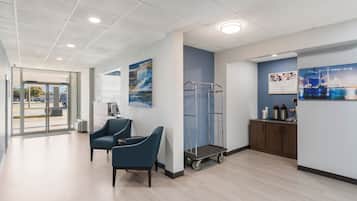 A modern interior with a reception desk, seating area, and a cart.