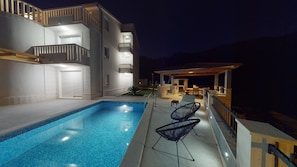 Una piscina al aire libre de temporada, sillones reclinables de piscina
