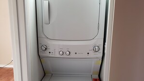En bild som visar en vit tvättmaskin med frontmatning, med knappar för inställningar och en gul energimärkning.