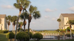 Un resort con edificios de varios pisos, palmeras y un césped bien cuidado.