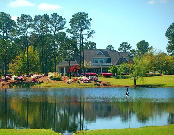 A large house with a pond in front, surrounded by trees and landscaped gardens. - 2705m 1 Bedroom Condo by RedAwning (Calabash)