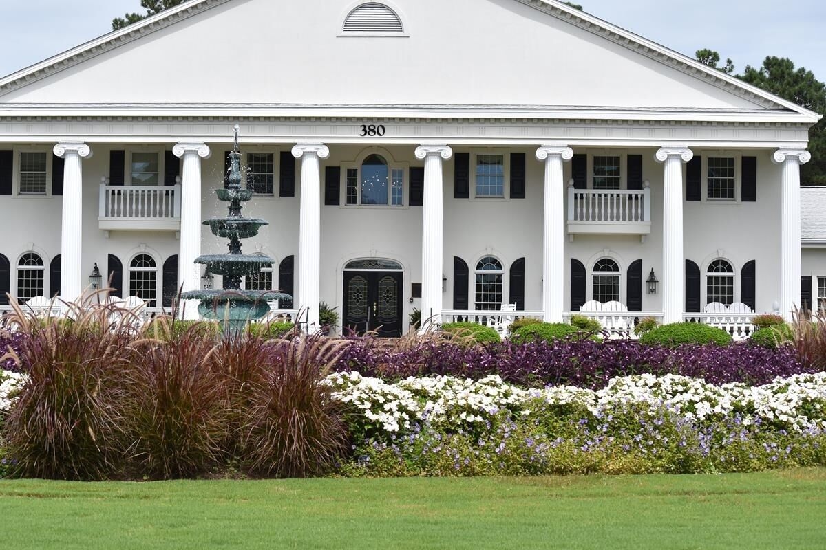 A large white building with columns, a fountain, and a number '380' on the facade.