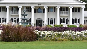 A large white building with columns, a fountain, and a number '380' on the facade. - 3008 2 Bedroom Villa by RedAwning (Calabash)
