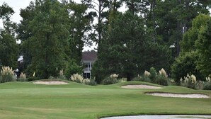 A golf course with bunkers, a water hazard, and a clubhouse in the background. - 3008 2 Bedroom Villa by RedAwning (Calabash)