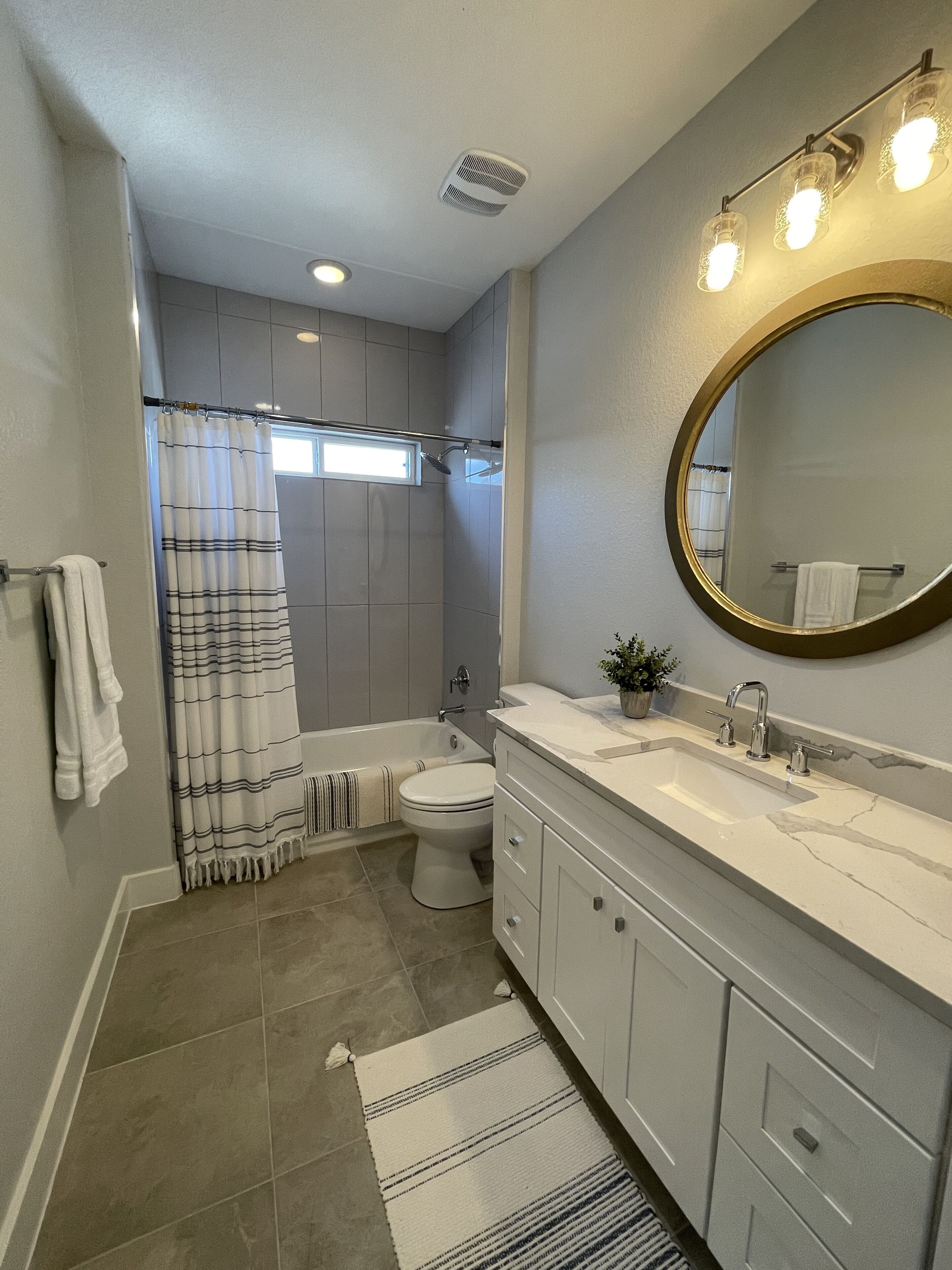 A modern bathroom with a bathtub, toilet, and sink.