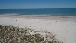 Une plage offrant une vue dégagée sur l’océan et dont le sol est sablonneux.