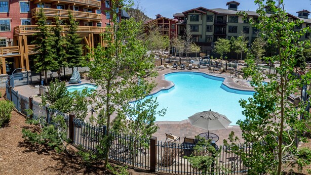 Een resort met een zwembad, meerdere gebouwen en buitenzitplaatsen.