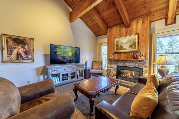 Grand living area with vaulted ceilings, large flatscreen TV gas burning fireplace.
