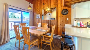 A wooden interior with a dining table, chairs, a kitchen area, and a large window. - 1 + Loft w/ Views Next to the Village at Mammoth! (Mammoth Lakes)