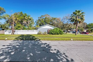 A residential street with a house, palm trees, and a clear blue sky. - FREE Heated Pool, Sleeps 10, Pinellas Pk | 25 Min to Gulf Beaches (Pinellas Park)