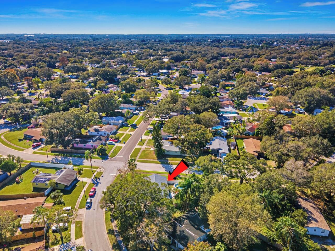 An aerial view of a residential area with houses, roads, and greenery.