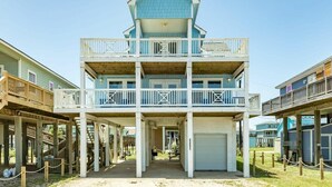 A multi-story building with balconies, a covered entrance, and a garage. - Annie by the Sea - Oceanfront, Sunrise & Sunset Decks! (Freeport)