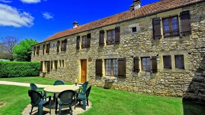 A stone building with a tiled roof, a central door, and multiple windows with shutters. - CORINNE - 6 people (ST CREPIN ET CARLUCET)