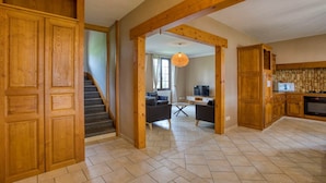 Amplia sala de estar con escaleras, armarios de madera y zona de cocina.