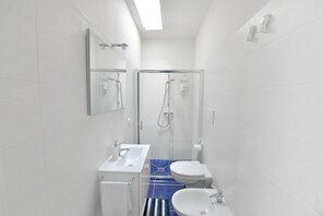 A modern bathroom with a glass shower enclosure, a white sink, and a toilet. - Il Marchese in Piscina (San Pietro In Bevagna)
