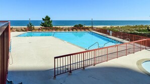 A pool area with a view of the beach and ocean. - Rainbow - Ocean Front 1 Bedroom Condo, Steps to the Beach! (Ocean City)