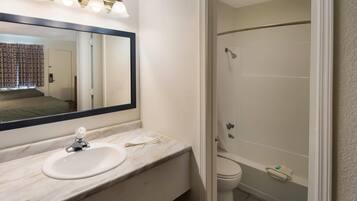 A bathroom with a sink, mirror, and shower.