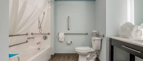 Une salle de bain équipée d’une baignoire, de toilettes et d’un meuble-lavabo avec un miroir.