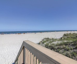 A beach with a wooden boardwalk leading to the shore.