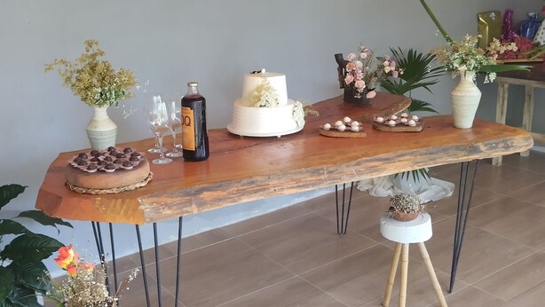 Een houten tafel met een taart, een fles en diverse decoratieve objecten.