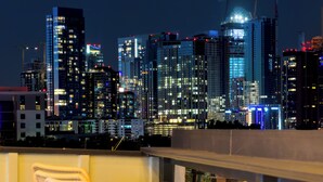 A city skyline at night with illuminated buildings.