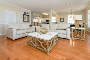 A living room with a sectional sofa, a coffee table, and a dining area with a table and chairs.