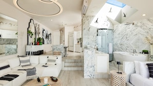 A modern interior with a living area, a bathroom, and a staircase leading to an upper floor.