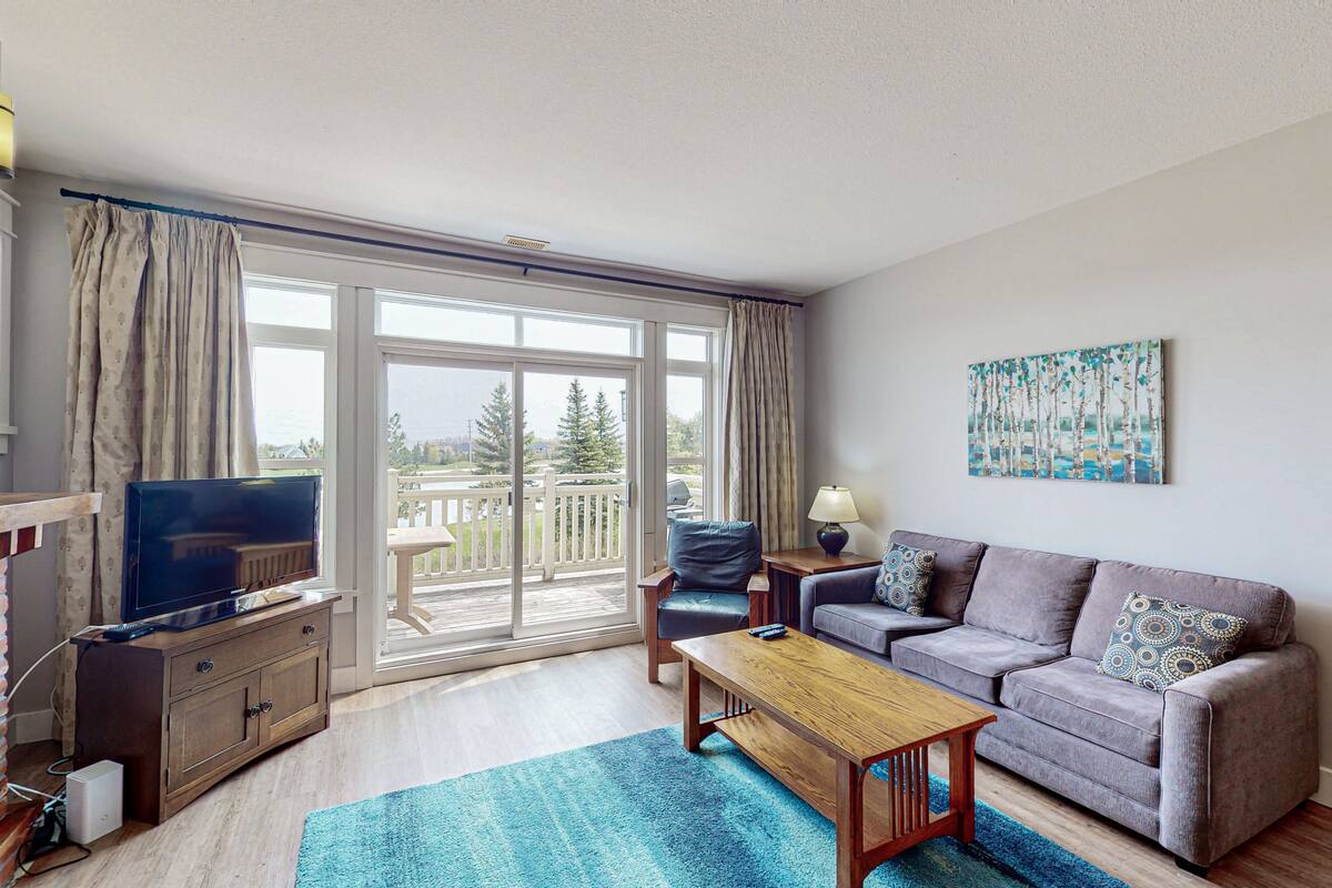 A living room with a television, sofa, and coffee table.