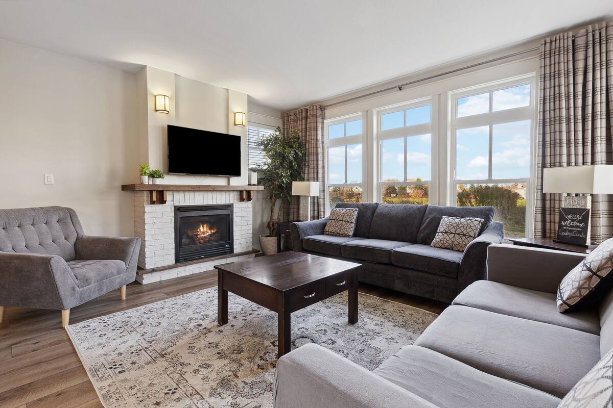 A living room with a fireplace, a sofa, a coffee table, and a television.