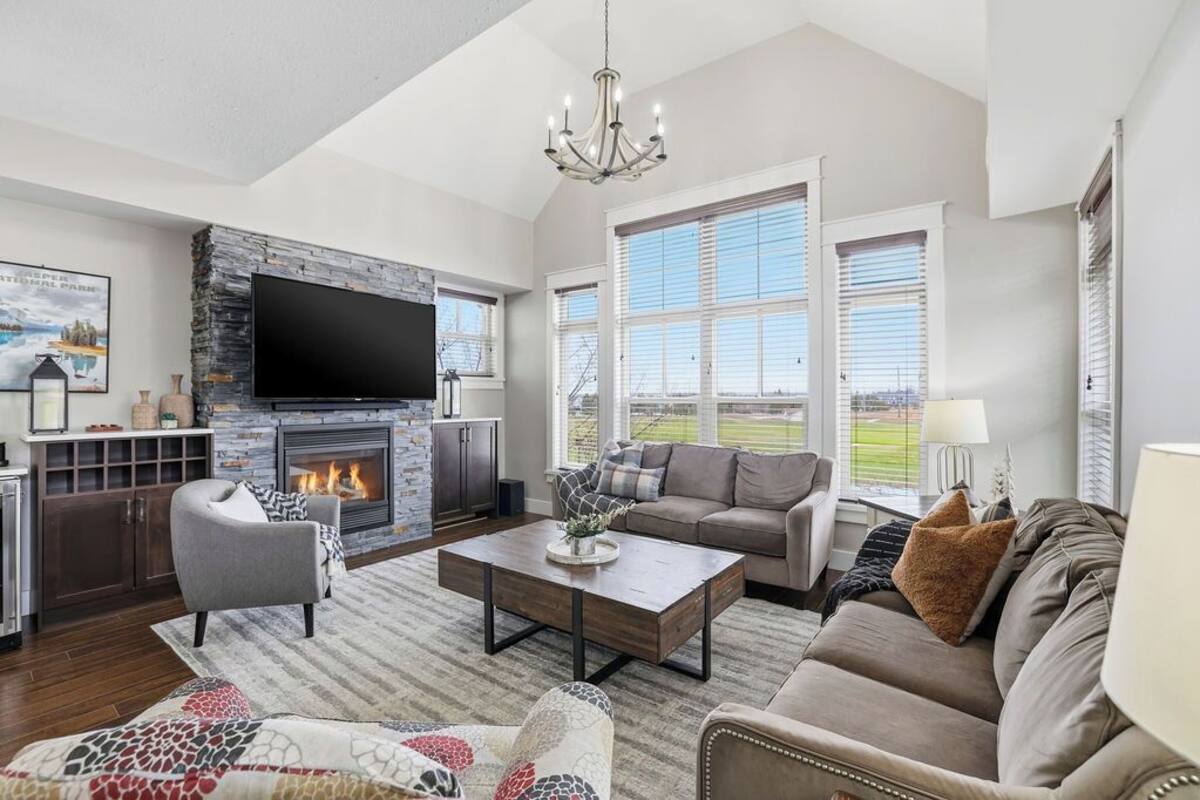 A spacious living room with a fireplace, a large flat-screen TV, and a comfortable seating area.