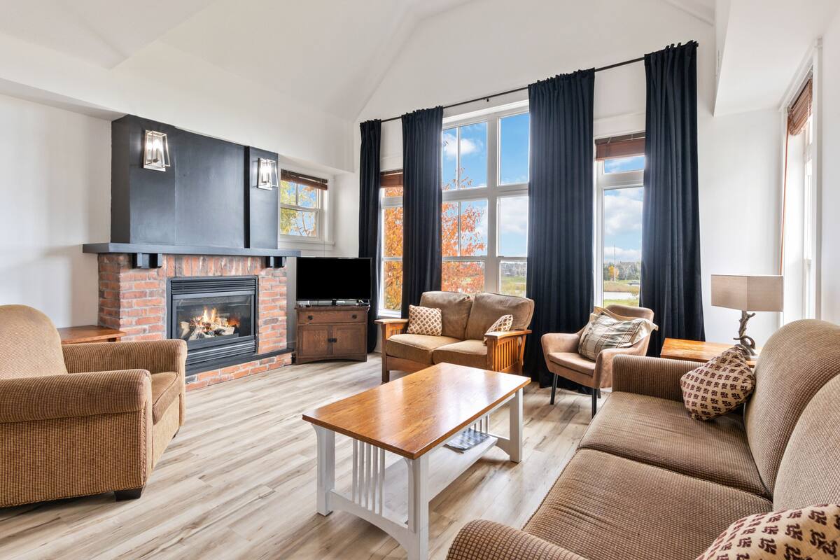 A living room with a fireplace, sofas, and a television.