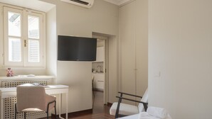 Une chambre d’hôtel équipée d’un lit, d’un bureau, d’une chaise, d’une télévision et d’une armoire.