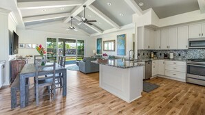 A spacious kitchen with white cabinets, a granite countertop, and a built-in oven.