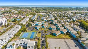 Zona residencial con edificios de varios pisos, una cancha de tenis y un estacionamiento.