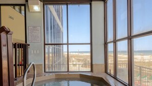 Un jacuzzi avec vue sur la plage et un balcon.