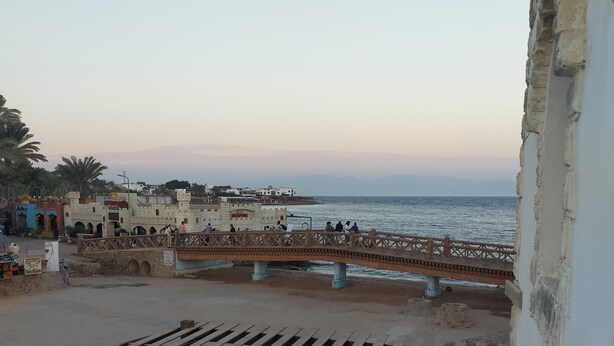 A balcony with a view of the sea, a wooden deck, and a stone wall. - Best location (Dahab)