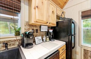 Enjoy a convenient kitchen with a coffee maker, refrigerator, and window with blinds.