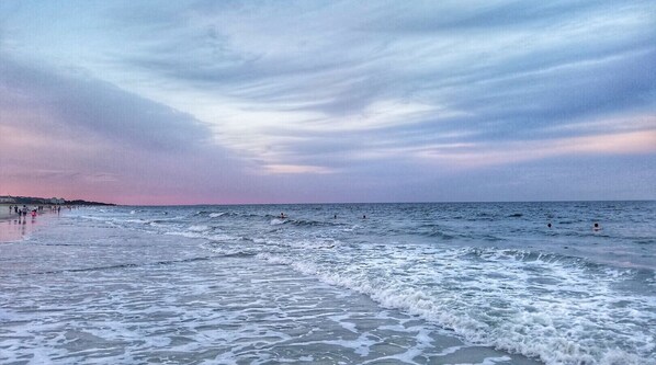 Guests can enjoy a serene beach experience with calm seas and a clear sky.