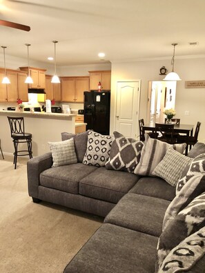Relax in this stylish living room with a comfortable sofa and dining area.