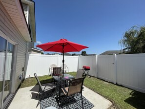 Enjoy al fresco dining on the patio, surrounded by a beautifully maintained lawn and a barbecue grill.