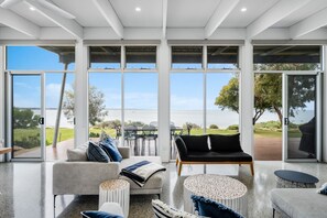Ein großzügiger Wohnbereich mit Meerblick, einer Holzdar Terrasse und modernem Interieur.