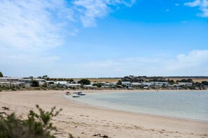 Ein Küstenstrand mit Häusern und Booten.
