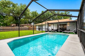 A rectangular swimming pool with a clear blue water surface, surrounded by a concrete deck. - Screened Heated Pool, Sleeps 12 | Game Room, 10 Min to Hard Rock Casino (Seffner)