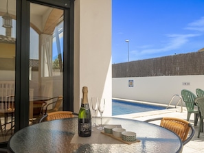 A glass table with a bottle of champagne, two glasses, and three decorative bowls. - Ref. VINYA: Ground floor house with swimming pool. (L'Escala)