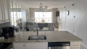 A modern kitchen with a granite countertop, stainless steel appliances, and a built-in dishwasher.