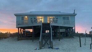 A two-story beachfront house with a balcony and a staircase leading to the upper level. - Cute Bungalow w/small pool!
Absolutely Beach Front! (Gulf Shores)