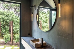 A modern bathroom with a large mirror, a rectangular sink, and pendant lights. - Mawhiti - Architecture & Beach Access Near Oneroa (Waiheke Island)