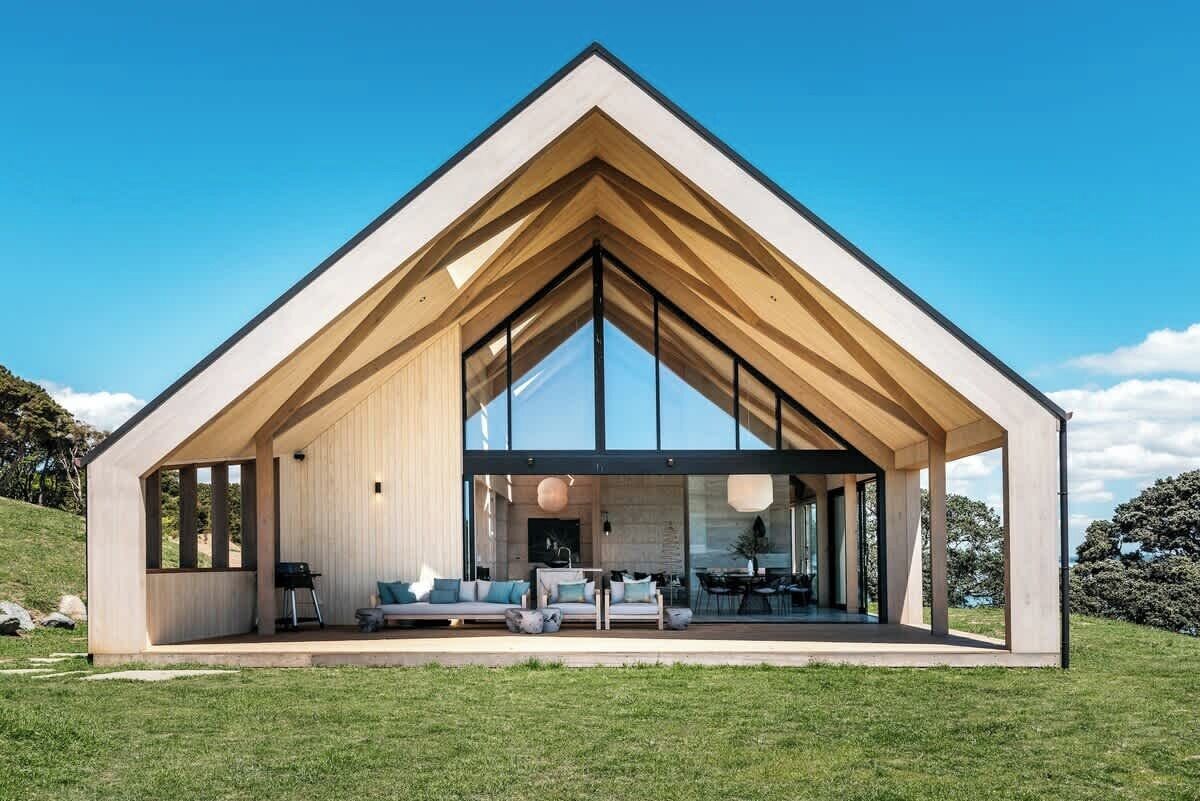 A modern house with a large open-plan living area, large windows, and a sloped roof.