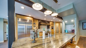 A kitchen with a marble countertop, stainless steel appliances, and pendant lighting. - Hot Tub, Game Room & More! Lakefront Home in Afton (Afton)